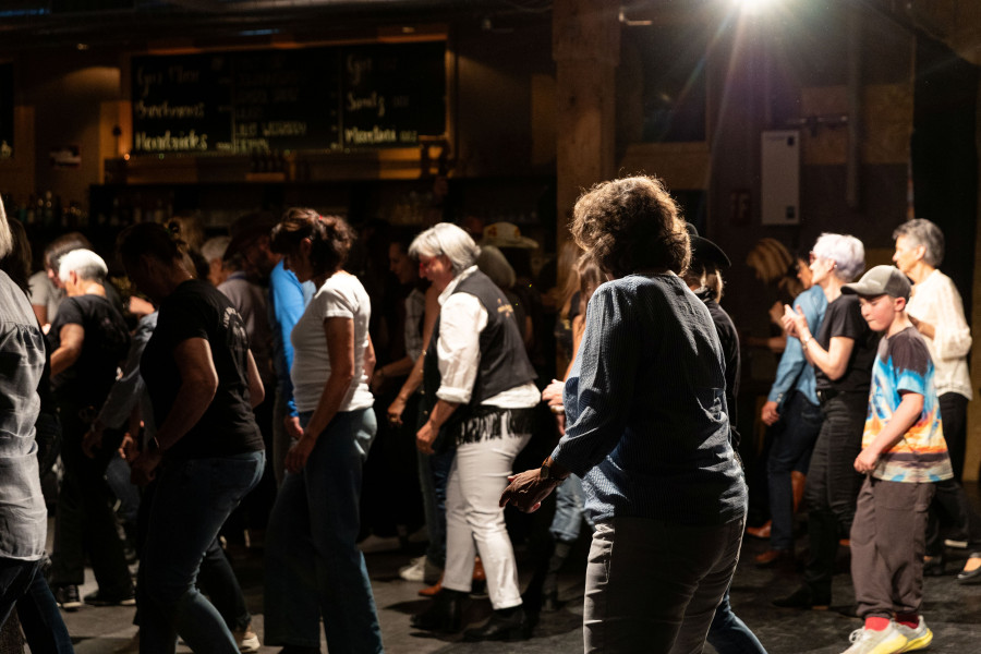 Man sieht ein volles Bistro mit tanzenden Personen: alt und jung gemischt