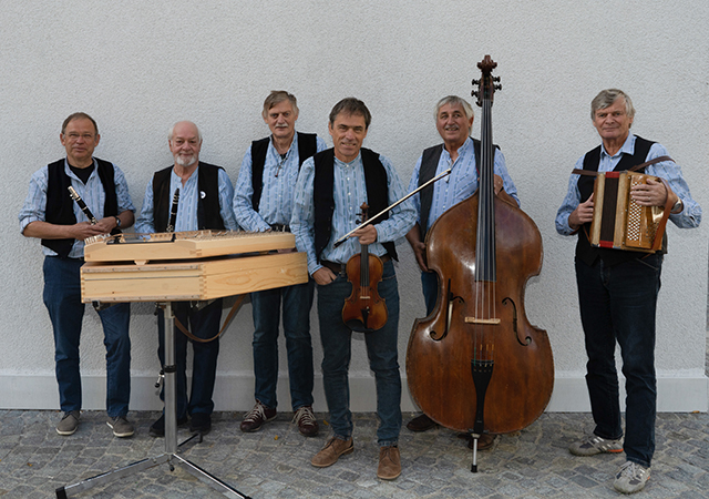Auf dem Bild sieht man die Sechs Musiker der Ländlerwerkstatt Oberwallis mit zwei Klarnetten, Hackbrett, Geige érgeli und Kontrabass