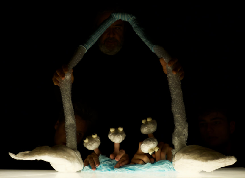 Personnages de marionnettes, on aperçoit les mains qui les manipulent.