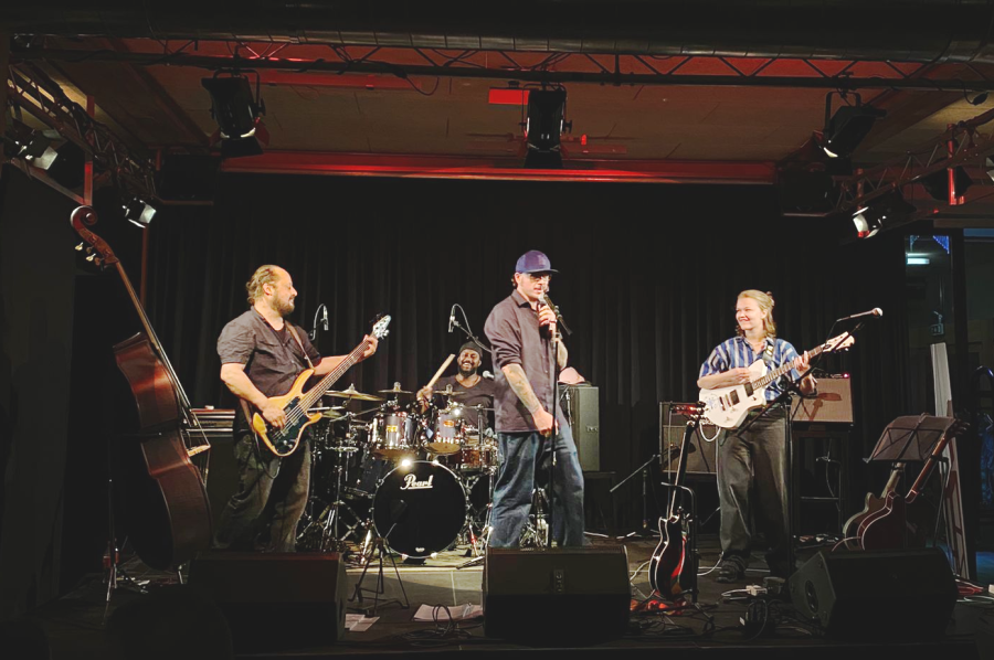 Die Bandmitglieder performen auf der Bühne im Bistro