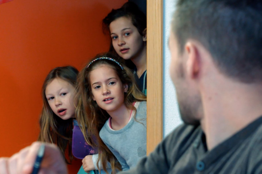 3 fillettes regardent leur professeur de dos